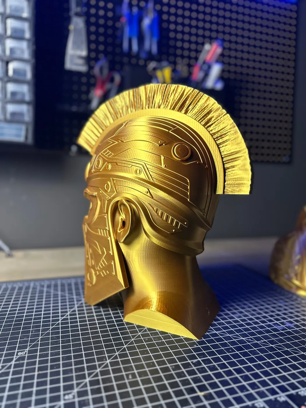 Gold 3D printed cyber Spartan helmet bust on a cutting mat