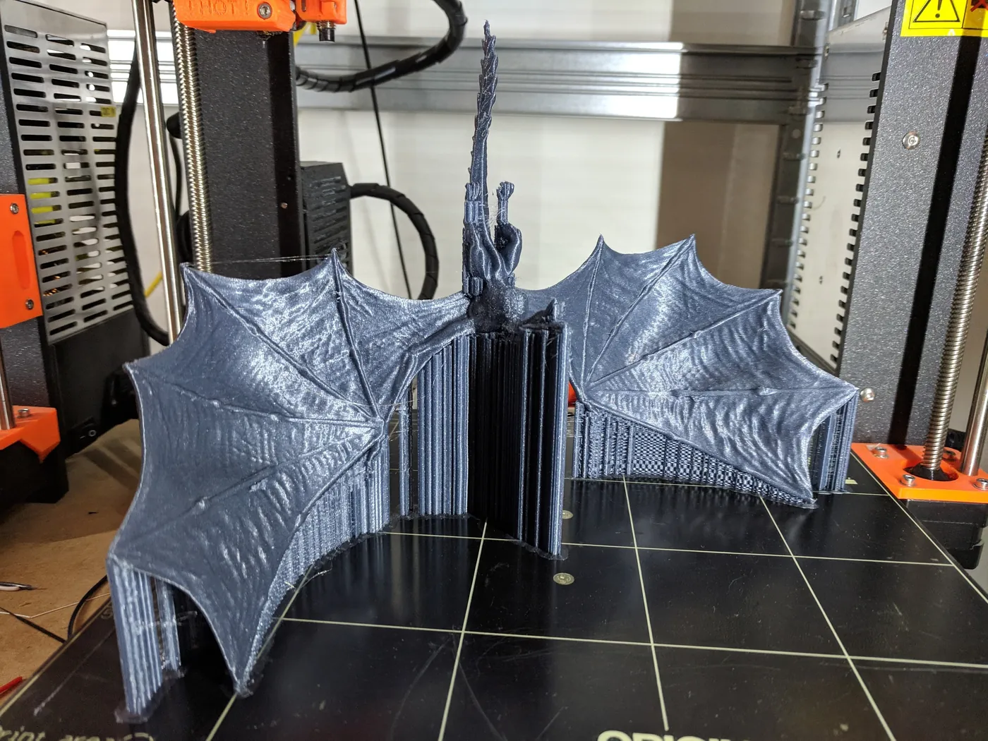 Large 3D printed dragon with spread wings on a 3D printer bed