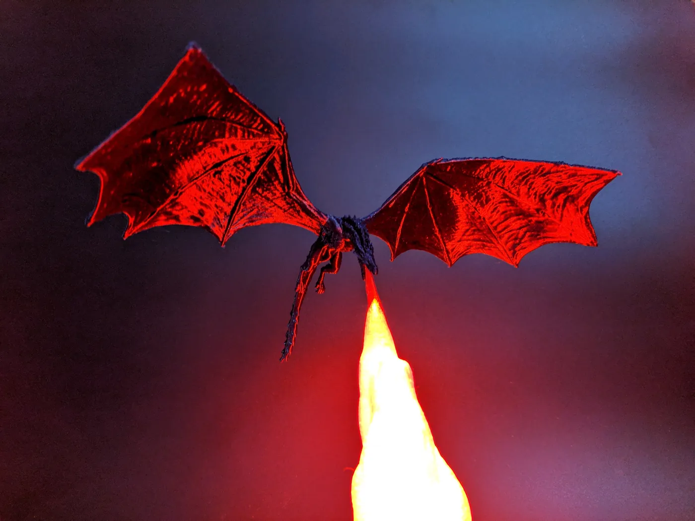 3D printed dragon lamp glowing red with a flame-shaped light