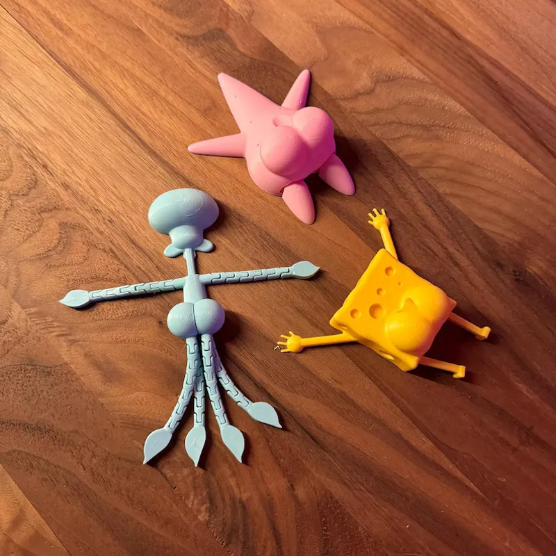 Set of 3D printed cartoon sea character figures on a wooden table