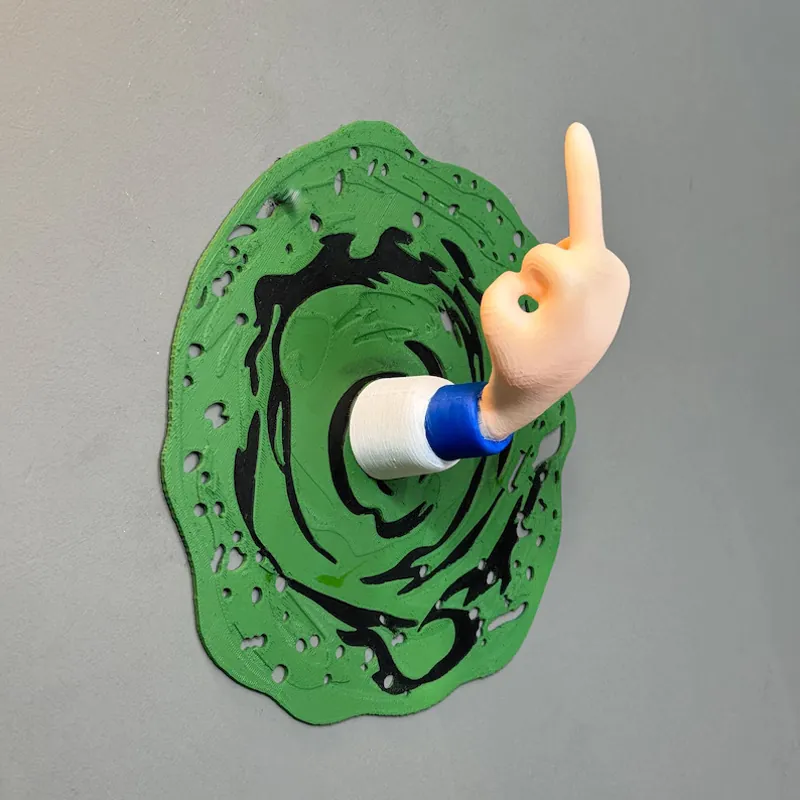 3D printed hand reaching out of a green portal mounted on a wall