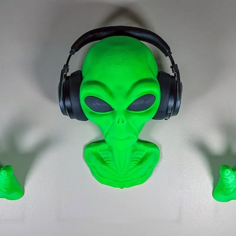 Green 3D printed alien head wall mount holding headphones